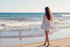 海岸を裸足で歩く女性